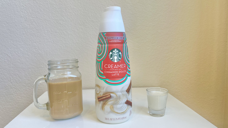 Starbucks Cinnamon Dolce Latte Creamer in bottle, shot glass, and jar of coffee