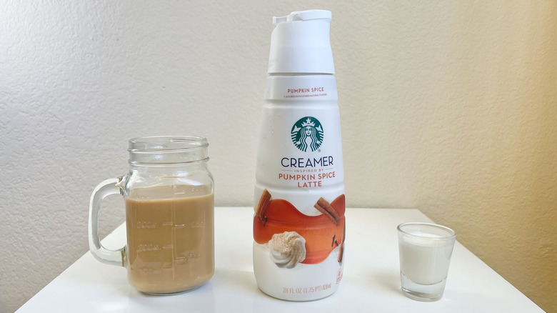 Starbucks Pumpkin Spice Latte Creamer in bottle, shot glass, and jar of coffee