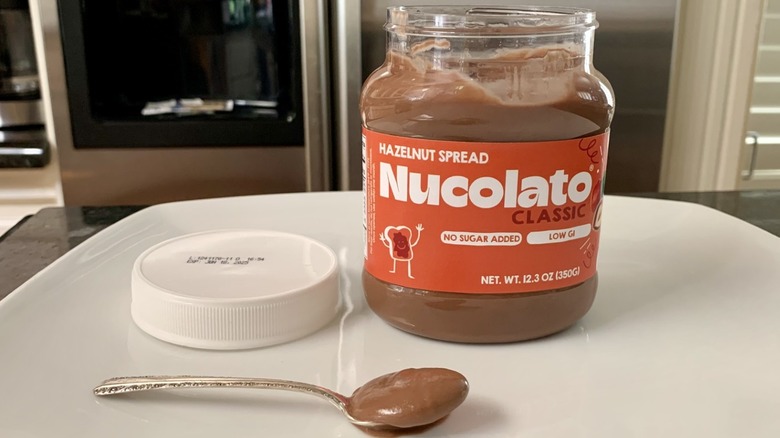 Container of Nucolato Hazelnut Spread with spoonful of it