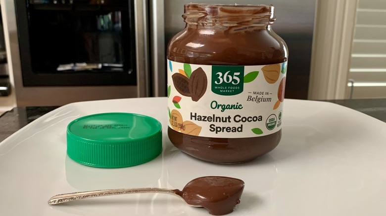 Opened jar of 365 by Whole Foods Market Organic Hazelnut Cocoa Spread with spoonful of it