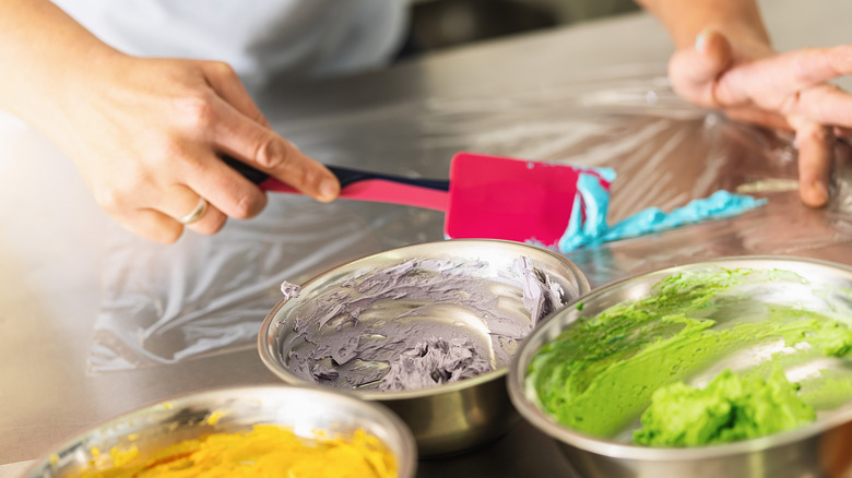 Person setting up bag with different colored frosting