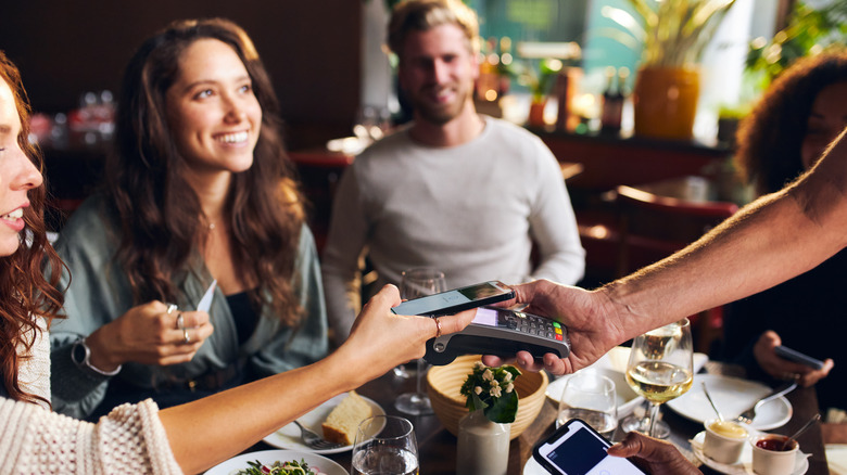 Friends paying bill at restaurant