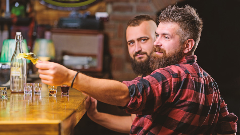 Man handing tip to bartender