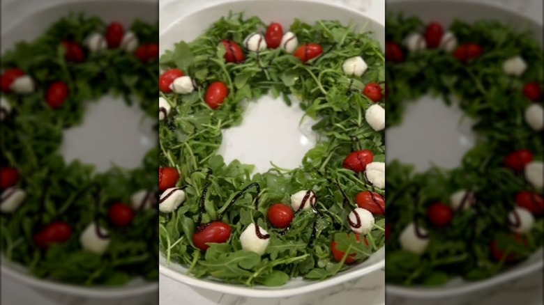 arugula, tomato, and mozzarella salad arranged in shape of Christmas wreath