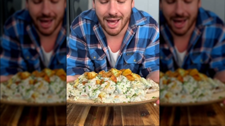 man holding platter of crispy potato salad