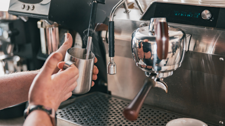 Barista steaming milk at angle