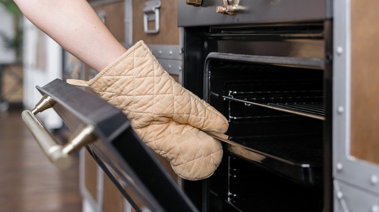 hand putting tray in oven