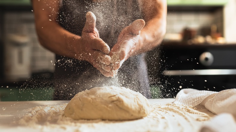 floured hands over dough