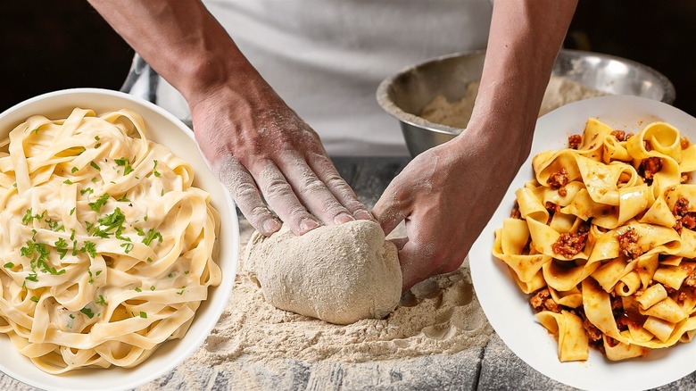 A man kneading pasta dough on a flat flour dusted surface surrounded by a bowl of flour and two bowls filled with different pasta dishes