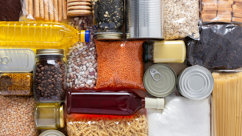 Close-up of various dry, bottled, and canned goods arranged on table