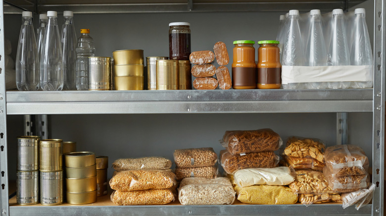 Unlabeled bag, jars, and bottles of food and water on grey shelving unit