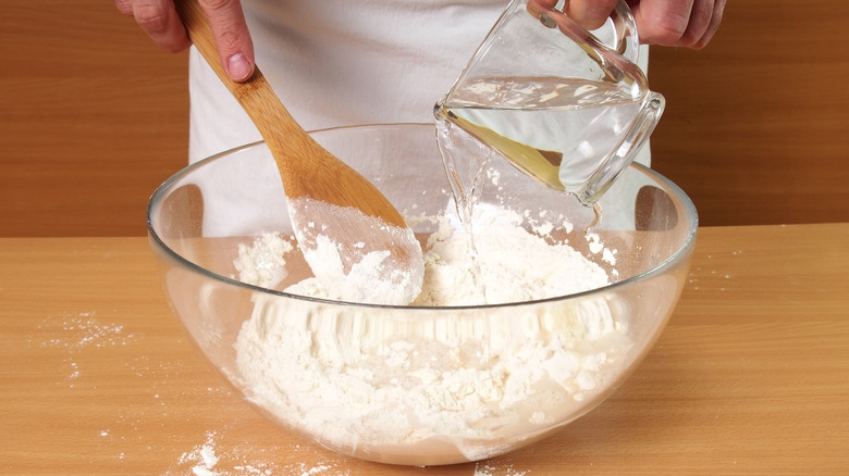 pouring water into flour