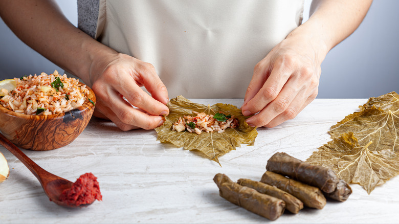 hands rolling grape leaves 