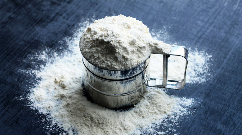 Measuring cup heaped with flour