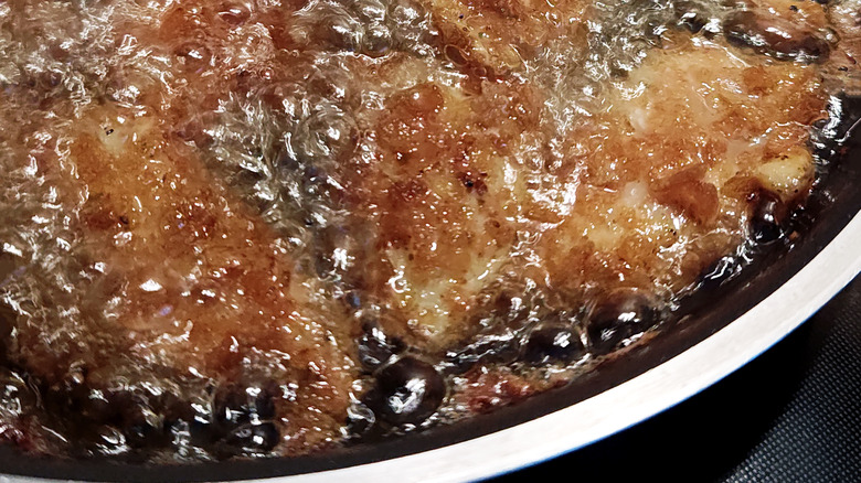 Closeup of oil bubbling while something fries