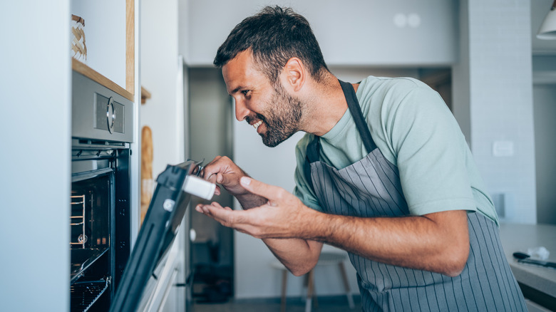 Man opening oven door 