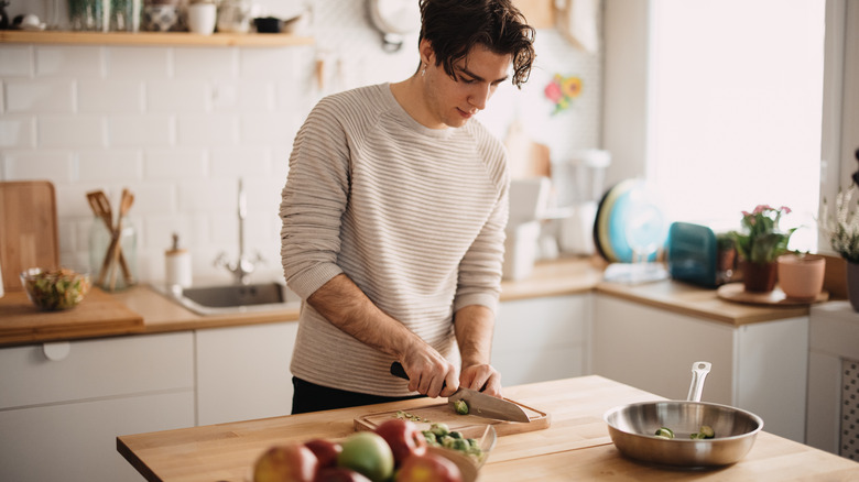 Person chopping brussels on board