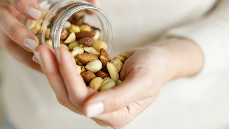 Woman pouring nuts into hand