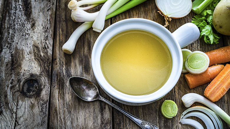 Vegetable broth surrounded by vegetables