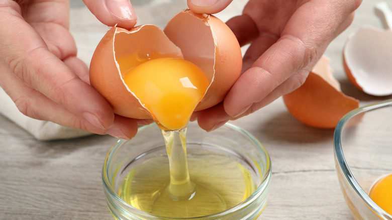 hands seperating egg yolk