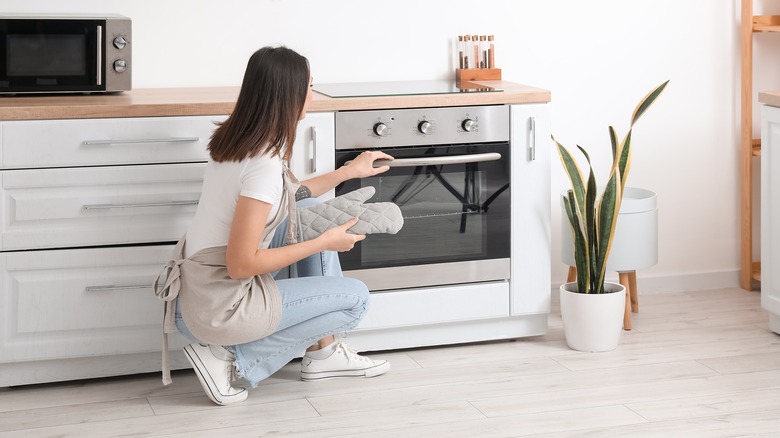 Women opening oven 
