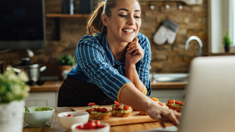 Woman checking recipe on computer