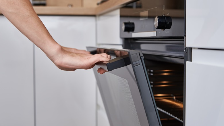 Hand opening an oven