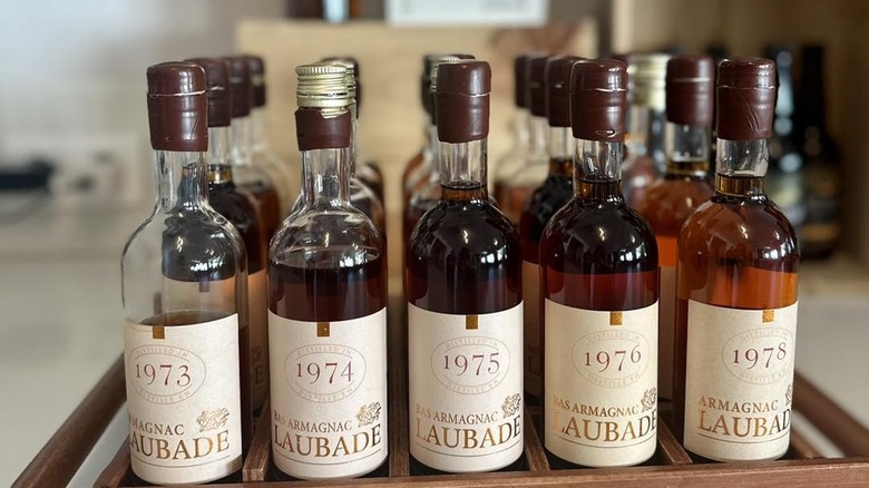 a wooden tray of Château de Laubade armagnac bottles