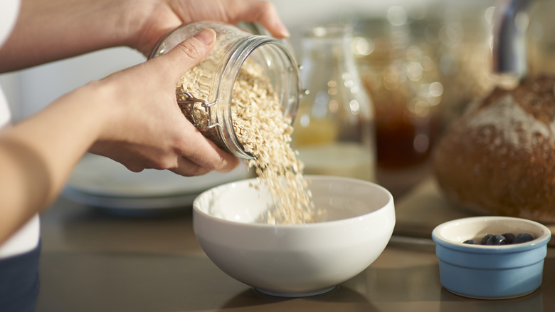 Pouring oats from a jar into a cereal bowl