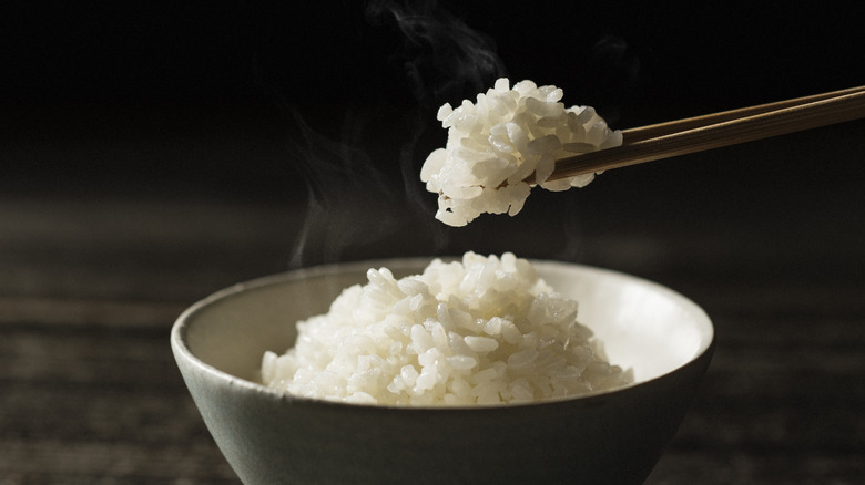 Lifting rice from bowl with chopsticks