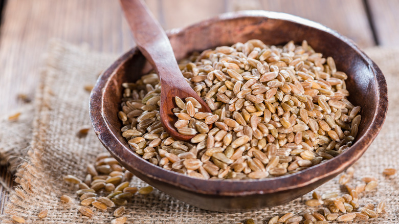 Wooden bowl containing spelt kernels