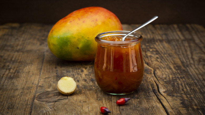 Mango and chile peppers with jar of chutney