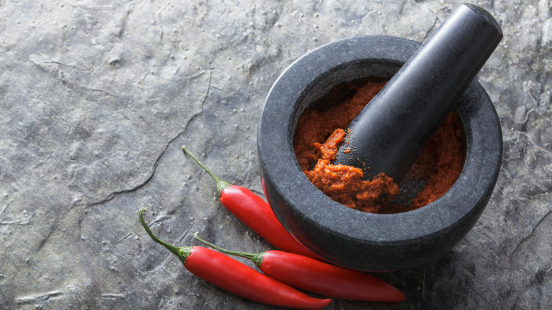 Red curry paste being crushed