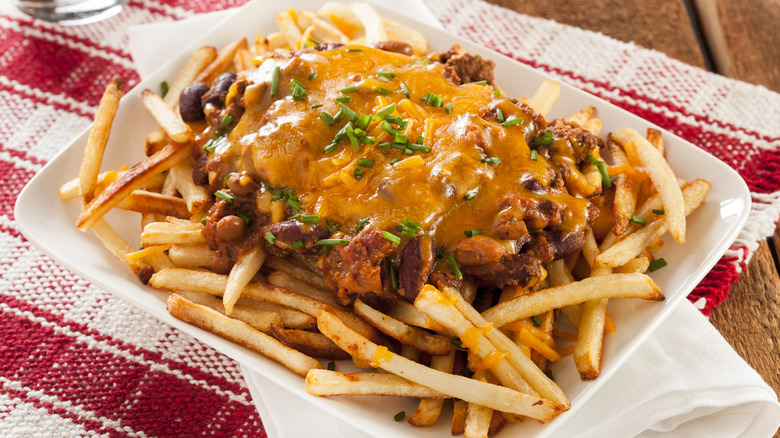 Chili cheese fries with chopped chive garnish