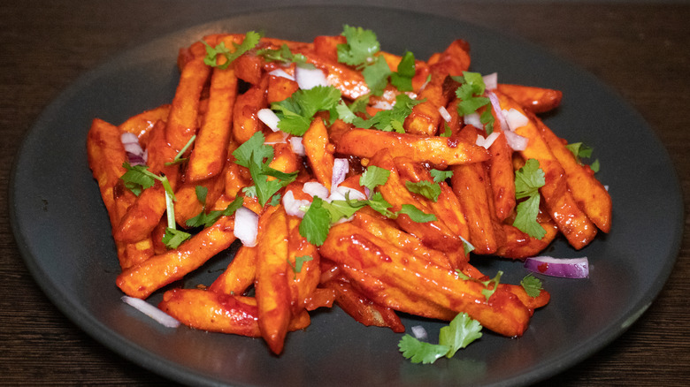 Plate of masala chips garnished with cilantro and red onion