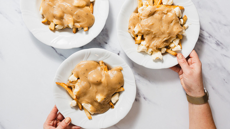 Three plates of Canadian poutine