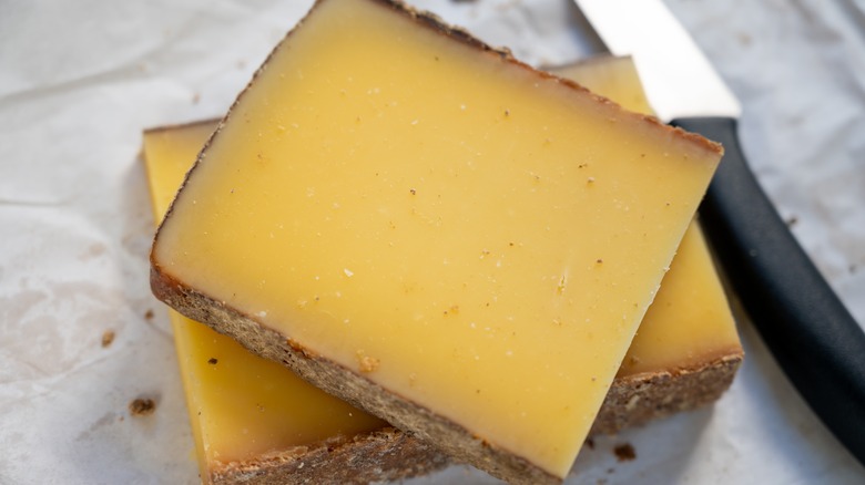 Thick slices of comté cheese with a knife
