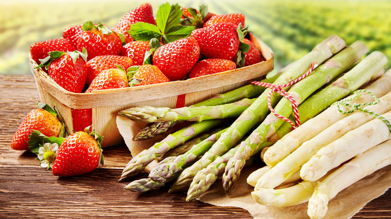 strawberries and asparagus on table