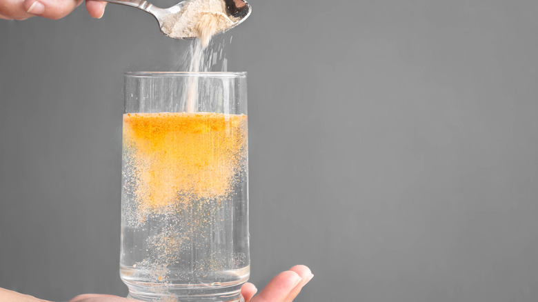 Mixing orange powder into a glass