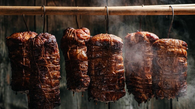 Pork hanging in a smoker