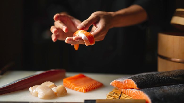 Person preparing salmon for sashimi