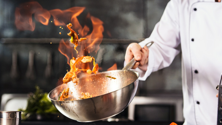Chef holding pan with fire