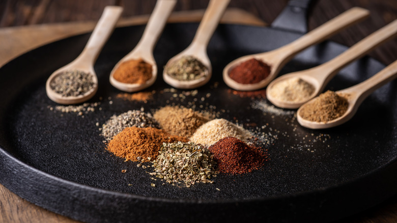 colorful herbs and spices wooden spoons