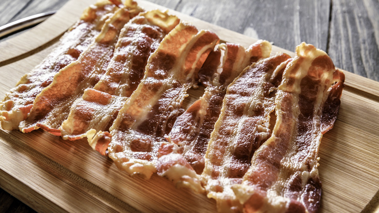 Fried streaky bacon on wooden board