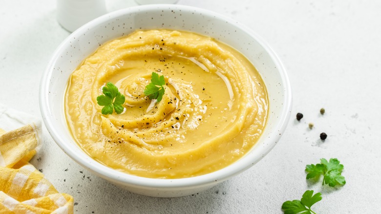 yellow colored hummus in a white bowl