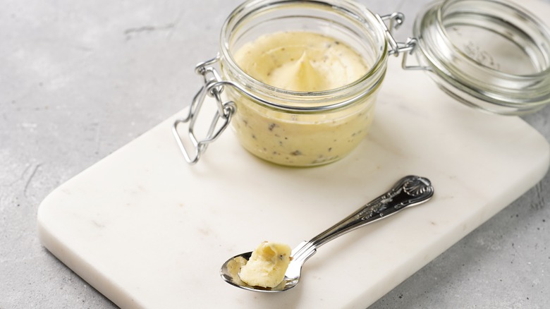 truffle butter in jar on cutting board with spoon