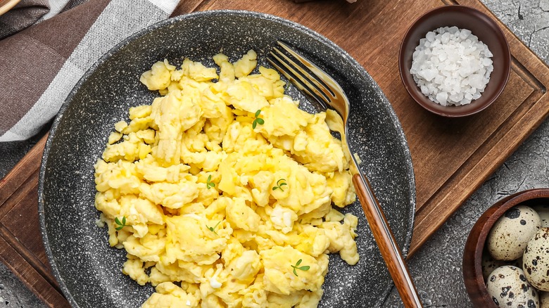 Scrambled eggs pictured with bowl of salt 