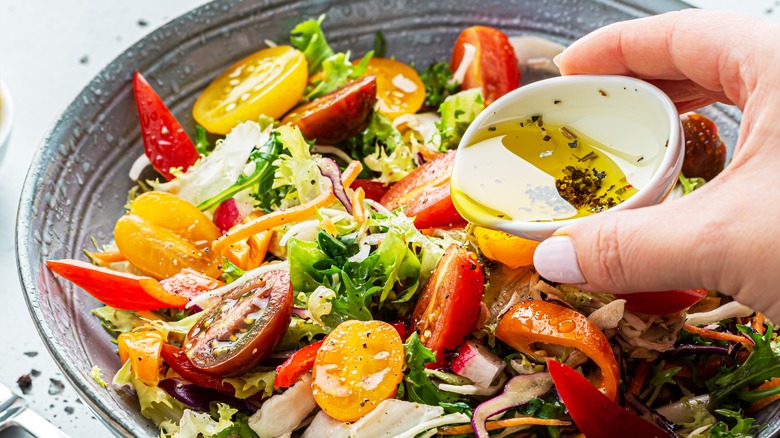 dressing being poured over salad