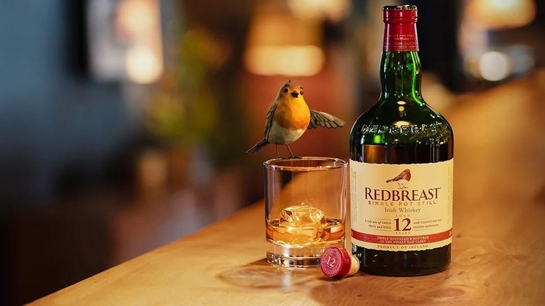 bottle and glass of Redbreast whiskey with robin