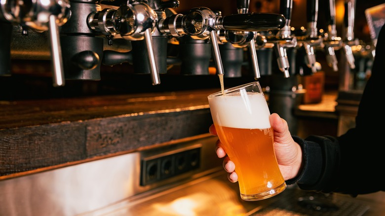 person pouring draft beer